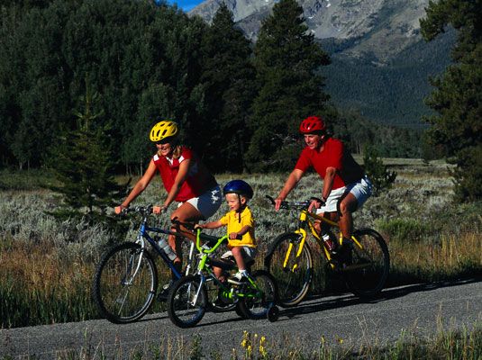 Faire du vélo ensemble est une façon d'être une famille verte. [Crédit: Corbis numérique Stock]